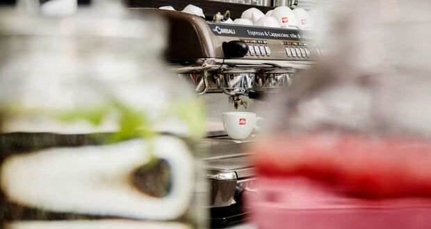 Unscharfe Espressomaschine mit Tassen an einer Café-Theke