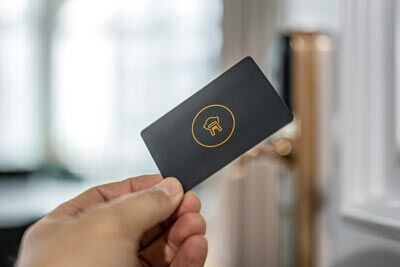 Hand hält eine Office Club Schlüsselkarte vor eine Tür