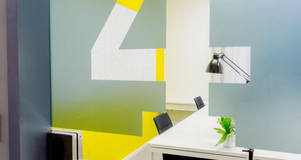 Wandgestaltung mit großer Ziffer 4 in Grau und Gelb und Schreibtisch mit Lampe