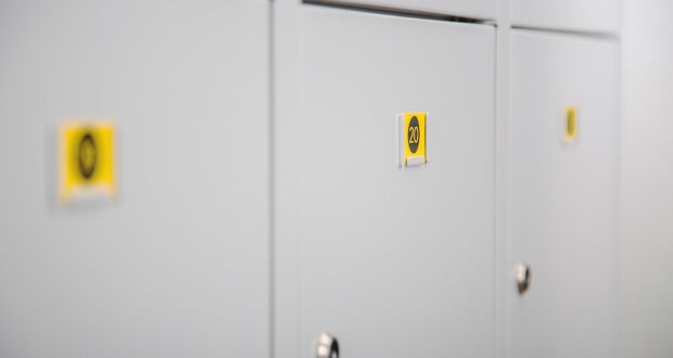 Weiße Schließfächer mit gelben Nummernschildern