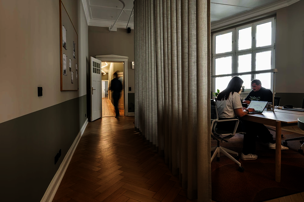Flur mit Fischgrätparkett und Vorhang im Office Club Berlin Kurfürstendamm, im Hintergrund eine Person an einer Tür