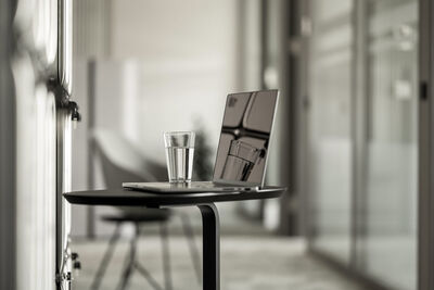 Stehtisch mit Laptop und Wasserglas im Office Club