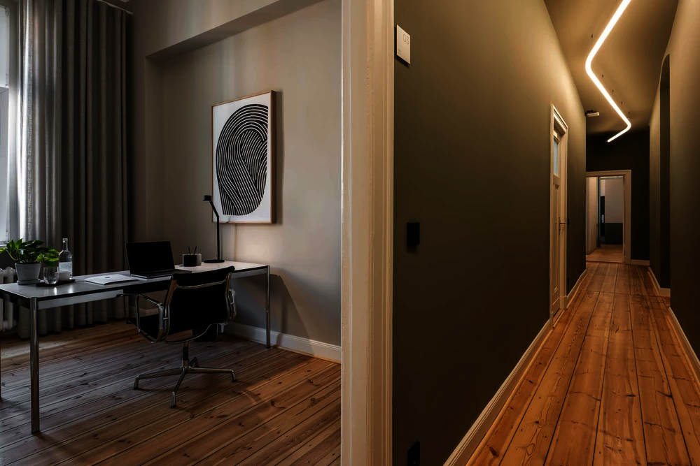 Einzelbüro mit Schreibtisch, schwarzem Bürostuhl und Wandbild im Office Club Berlin Kurfürstendamm