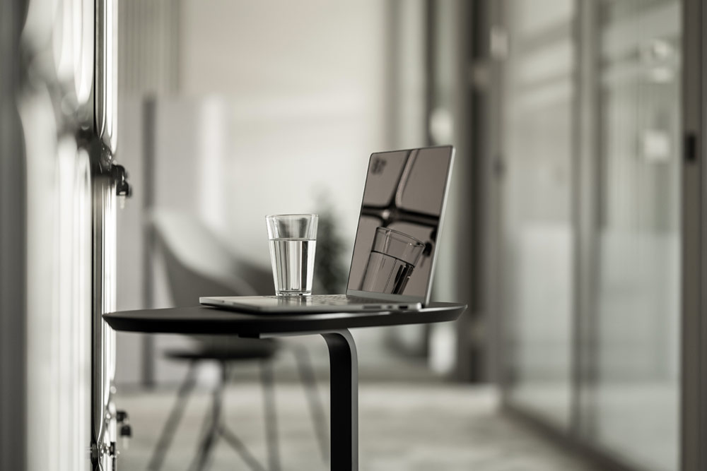 Stehtisch mit Laptop und Wasserglas im Office Club