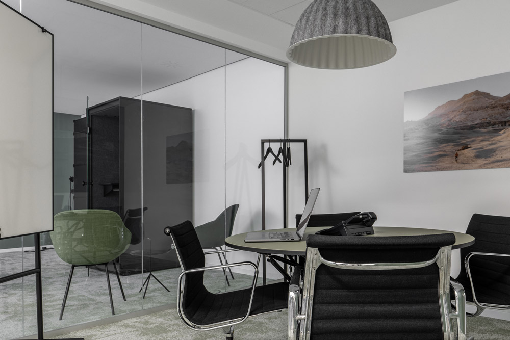 Besprechungsraum mit Glaswand, rundem Tisch und Whiteboard im Office Club Düsseldorf