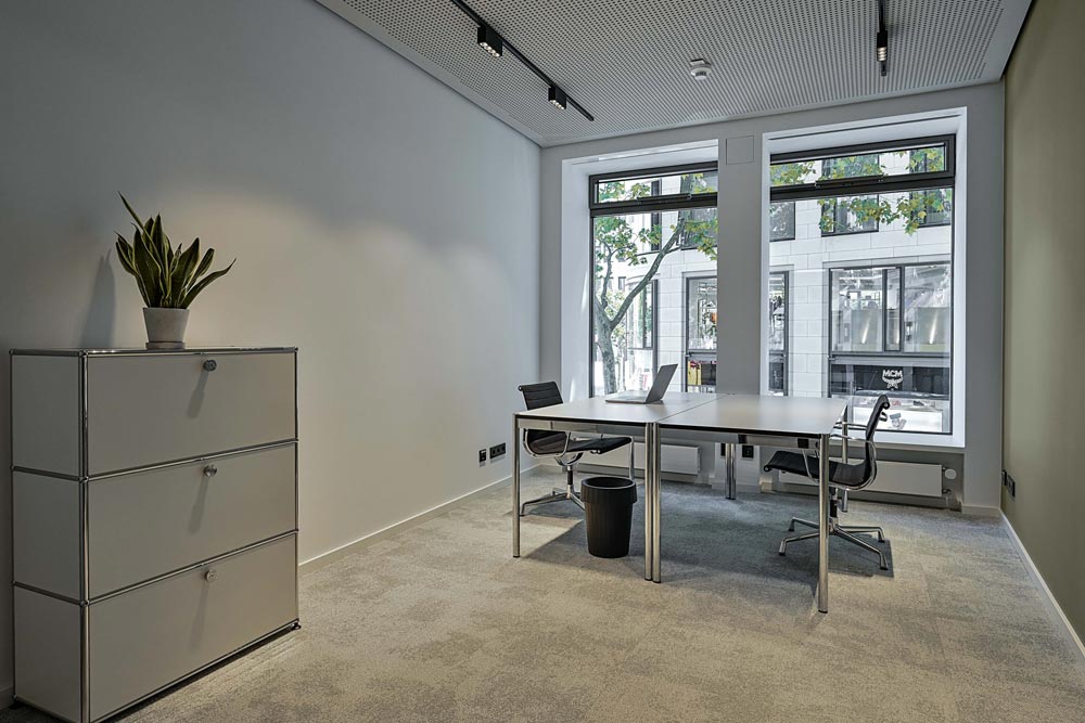 Büro mit Schreibtisch, Sideboard und großen Fenstern im Office Club Frankfurt Goethestraße