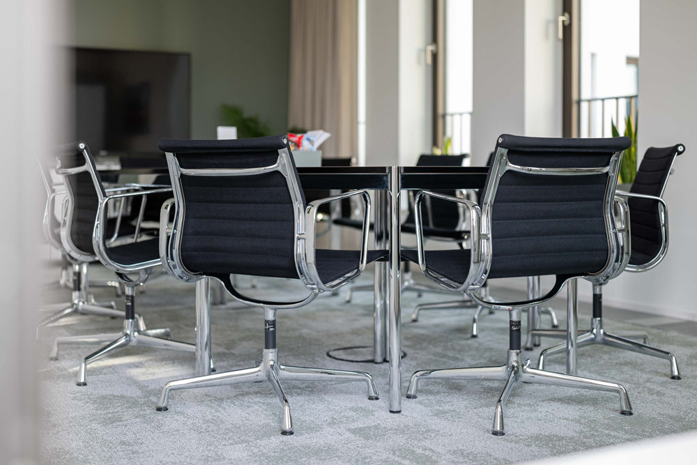 Seminarraum mit schwarzen Bürostühlen um einen Besprechungstisch im Office Club Hamburg