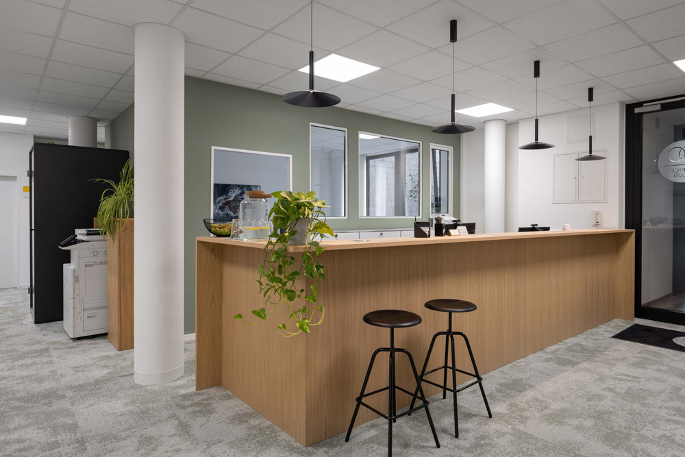 Empfang mit Holztheke, Barhockern und Pflanzen im Office Club Hannover