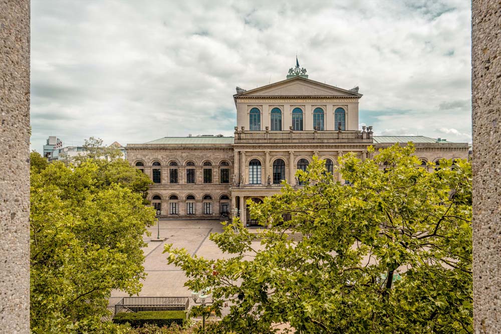 Blick über Bäume auf das Opernhaus Hannover