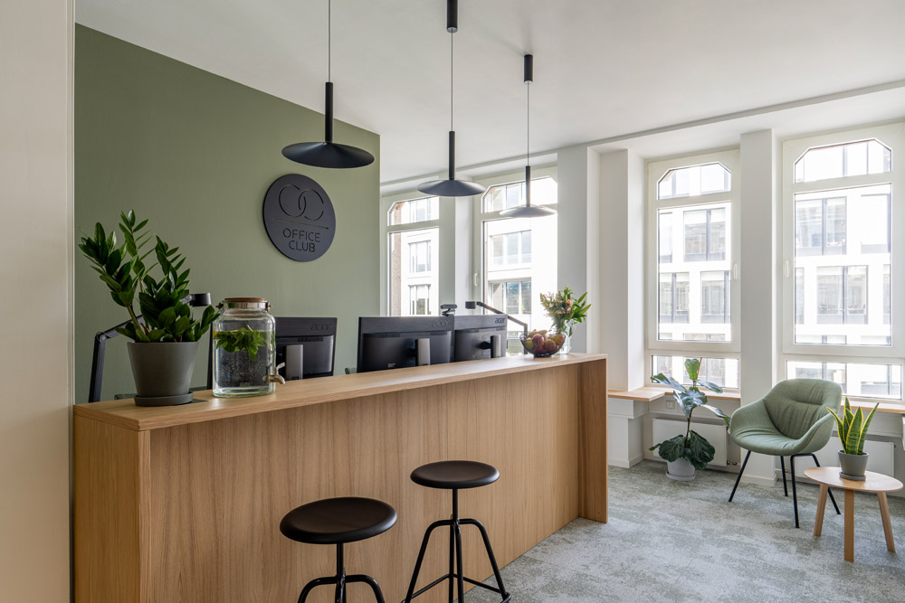 Empfang mit Holztheke, Barhockern und Pflanzen im Office Club Köln Hohenzollernring