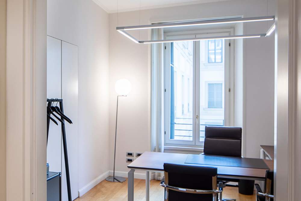 Tagesbüro mit Schreibtisch, schwarzen Stühlen und Fenster im Office Club Mailand