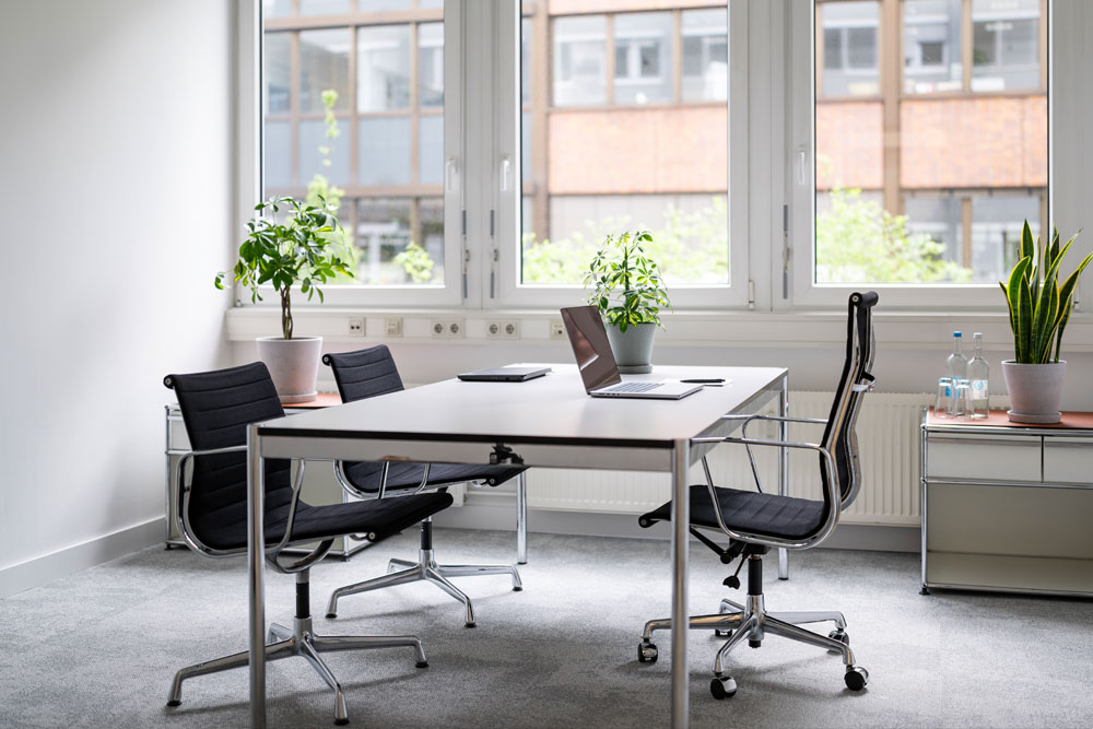 Büro mit Schreibtischen, schwarzen Bürostühlen und Pflanzen im Office Club Nürnberg