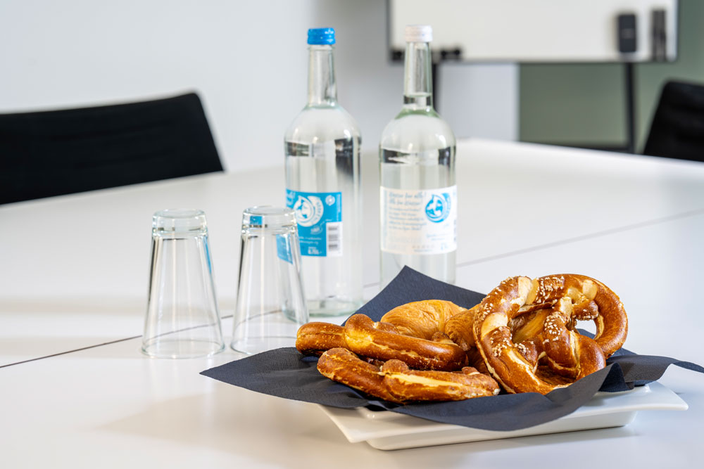 Konferenztisch mit Wasserflaschen, Gläsern und Brezeln im Office Club Nürnberg