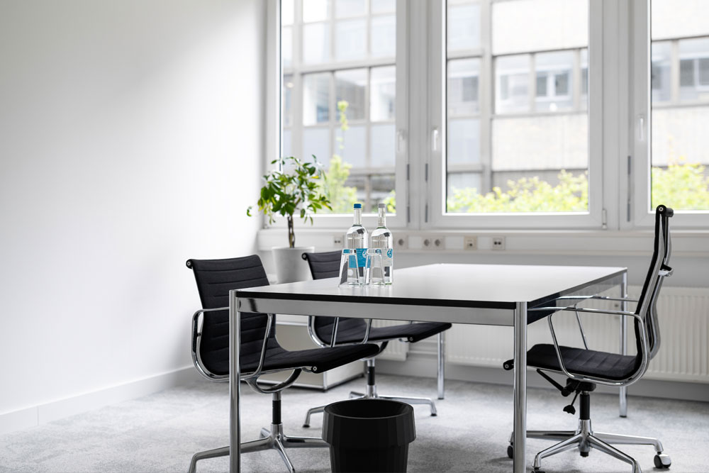 Tagesbüro mit Tisch, schwarzen Stühlen und Fenster im Office Club Nürnberg