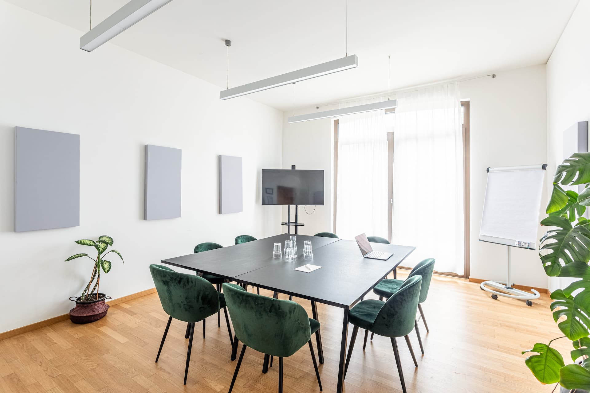 Heller Besprechungsraum mit dunkelgrünen Stühlen und Akustikpaneelen im Office Club Potsdam
