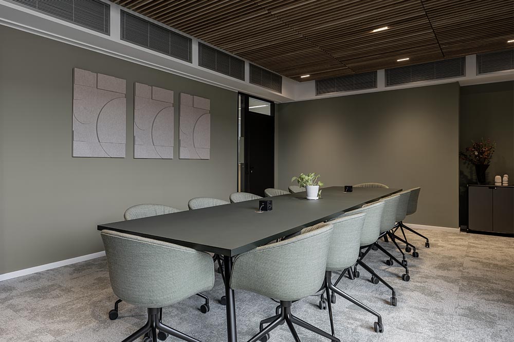 Meetingraum mit langem Tisch, grauen Stühlen und Holzlamellendecke im Office Club Stuttgart