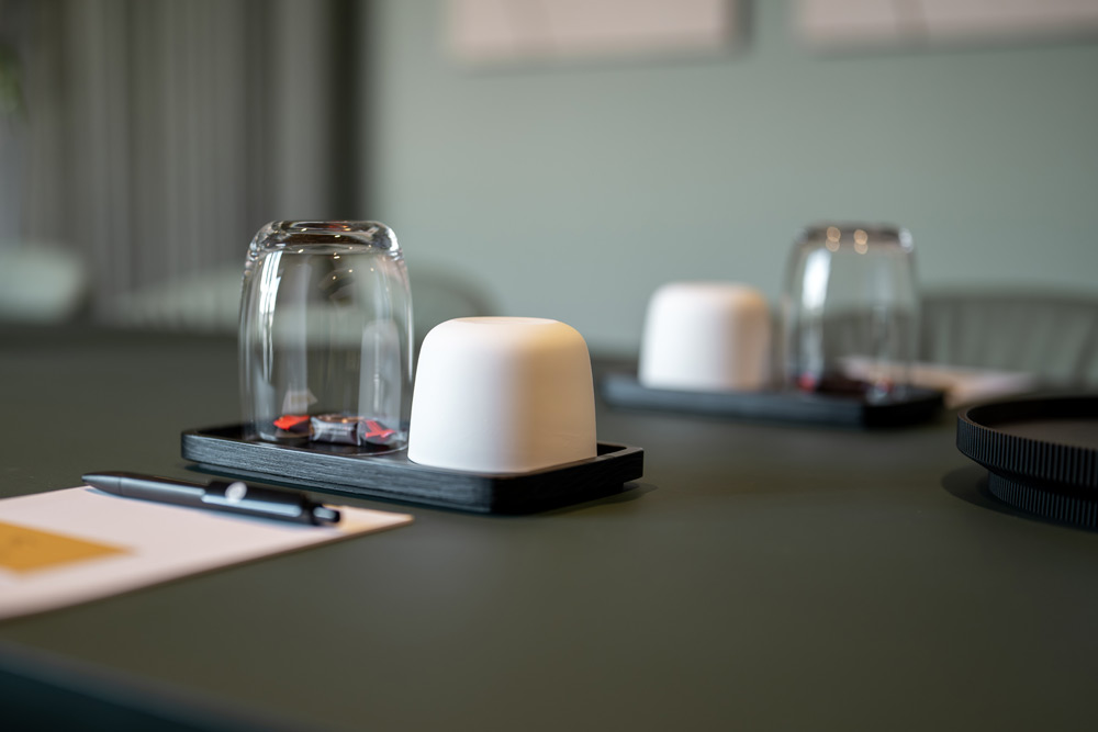 Vorbereiteter Besprechungstisch mit Glasbehältern und Notizblock im Office Club Stuttgart