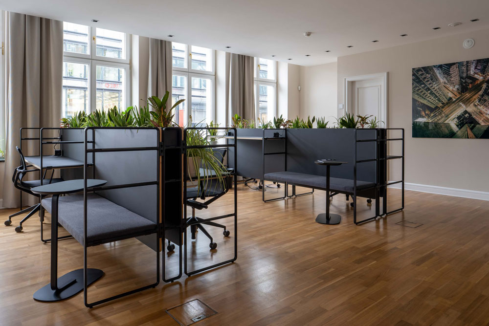 Arbeitsnische mit gepolsterter Sitzbank, Beistelltisch und Pflanzen im Office Club Berlin