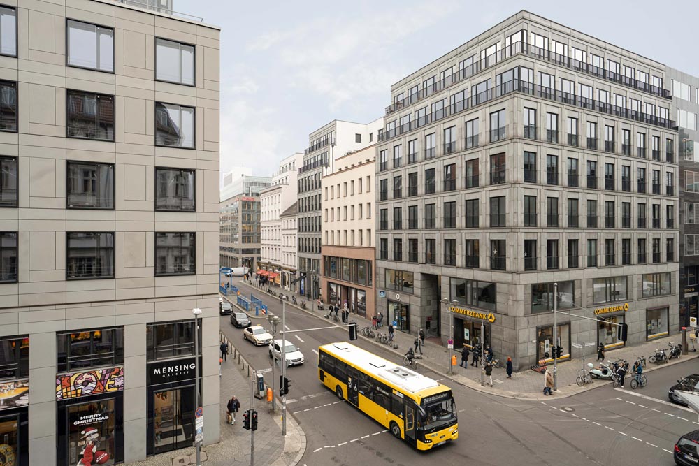 Blick von oben auf eine Straßenkreuzung an der Französischen Straße in Berlin Mitte mit Geschäftshäusern und gelbem Linienbus