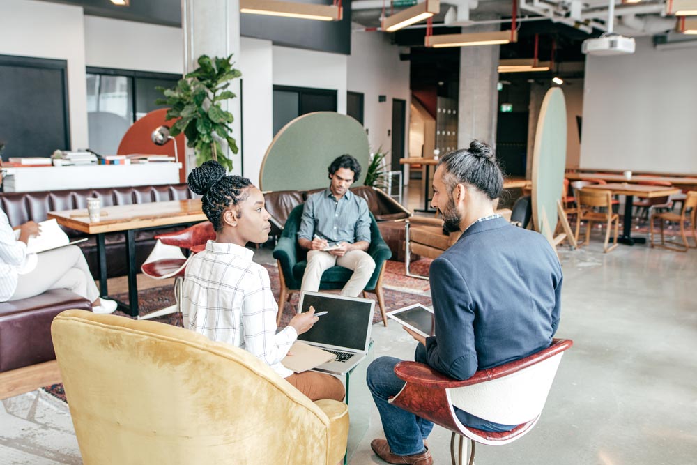 Menschen im Gespräch in der Lounge eines Coworking Space